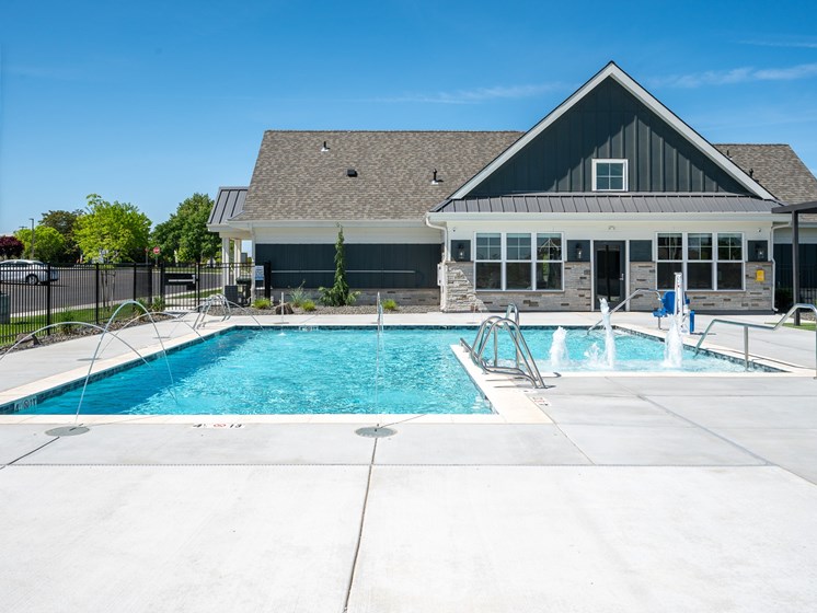 A clubhouse with a pool in front.